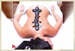 Woman lying face down with stones along her spine during massage therapy
