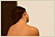 Woman's bare back, deep tissue laser pain relief in Orange County